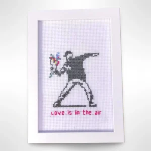 Håndlaget broderi inspirert av Banksys kunstverk "Love is in the Air". En unik dekorasjon for kunstelskere. Dimensjoner: 10 x 15 cm.