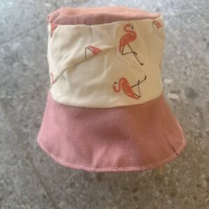 Vendbar bøttehatt med lyserosa flamingo-mønster på hvit bunn og rosa-skimmer brem